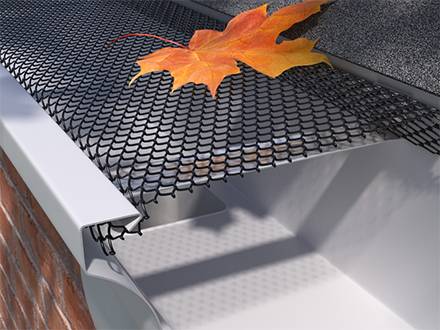 A leaf falls on the black expanded metal gutter guard cover