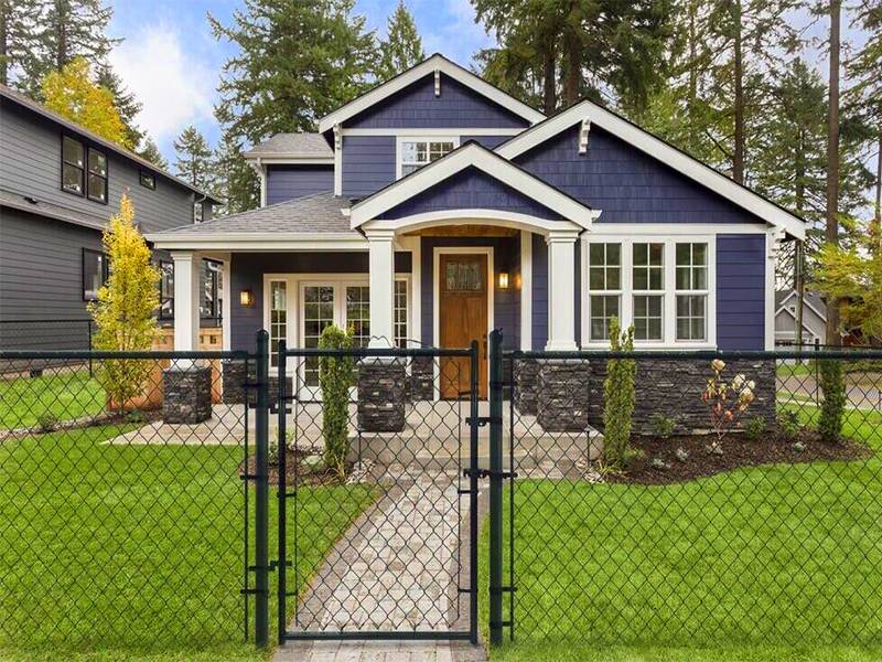 Chain link fence walk gate installed in small garden of villa