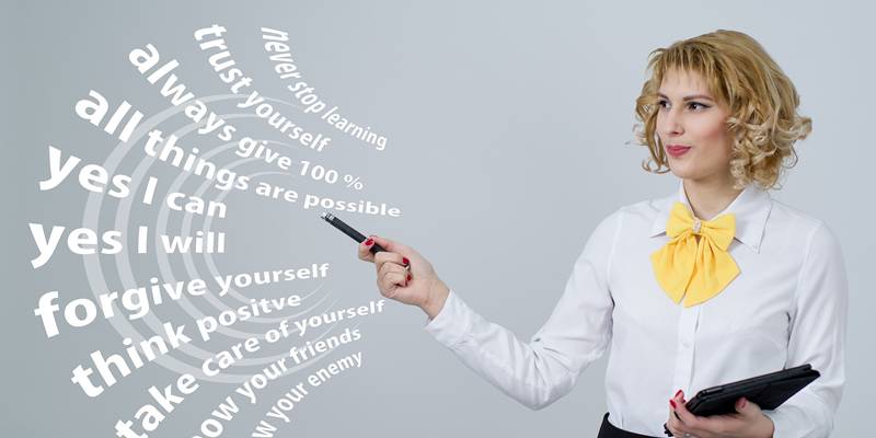 A business woman is pointing at the background board text with a pen