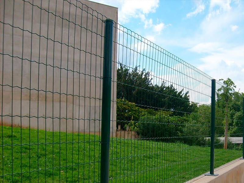 Big trees and green grass in the courtyard can be seen through the Euro Holland fence