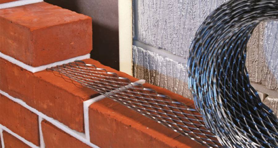 A coil of expanded metal brick reinforcement mesh unrolled on a wall under construction