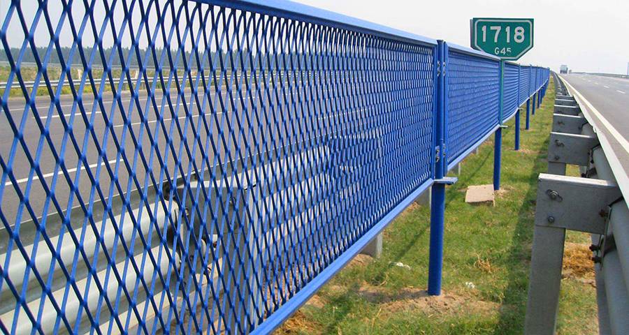 Blue expanded metal safety fence installed on the side of the highway